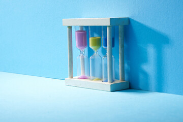 Hourglass with running sand over blue background