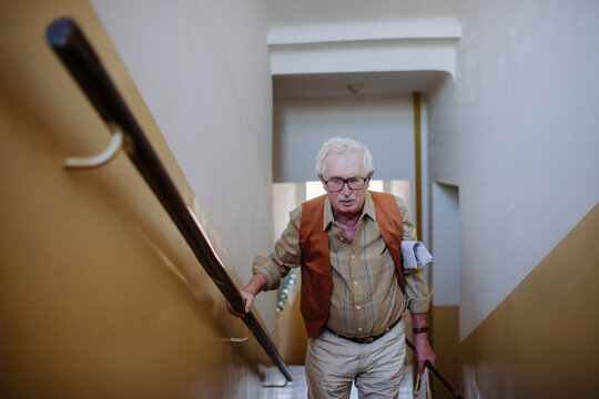 Senior man standing on staircase at home
