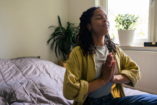 Woman with braided hair meditating at home