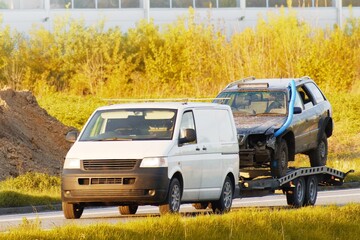 Tow truck carrying two wrecked car on trailer
