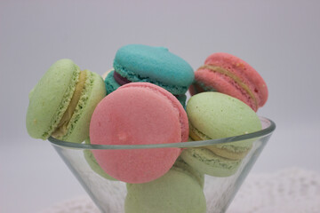 Colorful macarons in a glass bowl on lace