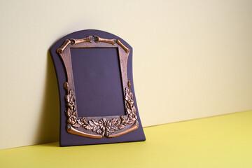 Wood plaque with brass frame isolate on yellow background