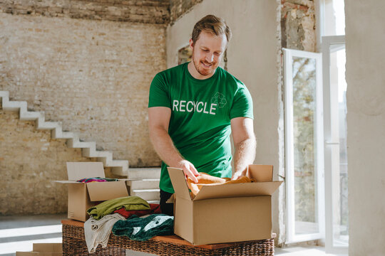 Smiling activist putting clothes in donation box