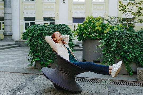 Businesswoman with hands behind head relaxing outside office