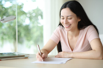Happy asian woman filling form or signing contract