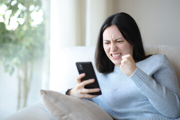 Angry asian woman checking phone at home