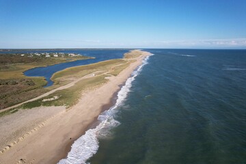 Aerial view of a coastal landscape with a sandy beach and ocean waves.