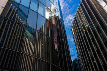 A captivating image of a curved glass building displaying intricate reflections of neighboring structures, blending urban architecture with artistic visual interplay  in London UK