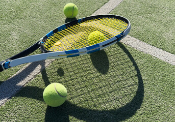 Tennis racket and tennis ball on court.