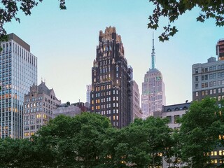 New York City skyline at twilight with lush greenery.