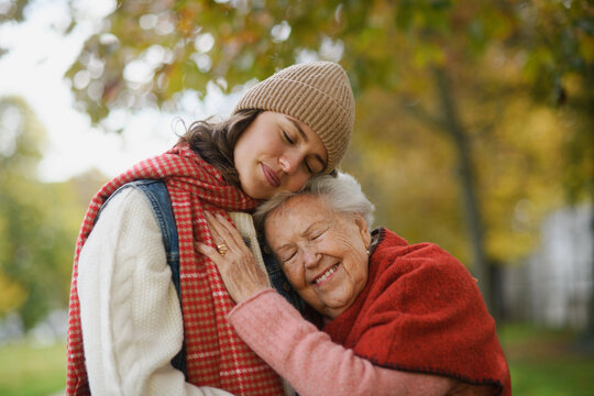 Portrait of a granddaughter on an autumn walk in the park with her grandmother.