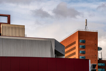 A geometric architectural design featuring blocky and angular building forms set against a cloudy sky, highlighting the interplay of form and urban environment in Rotterdam