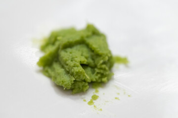 Fragrant wasabi powder. Fragrant wasabi powder on white dish.  Spicy wasabi paste on white background (dof)
