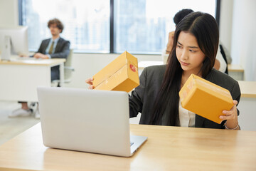 businesswoman checking parcel cardboard boxes from online shopping in the office