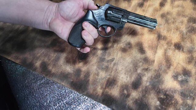 Gun in hands. Man loading gun. Gun and cartridges. Weapon. Self-defense. Shooting. Cartridges and gun in hands.
