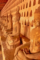 Many ceramic buddha statues, sculptures lined up in a row in the cloister wall of Wat Si Saket, a...