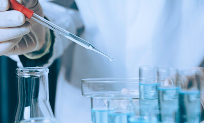 Researcher with glass laboratory chemical test tubes with liquid for analytical , medical,...