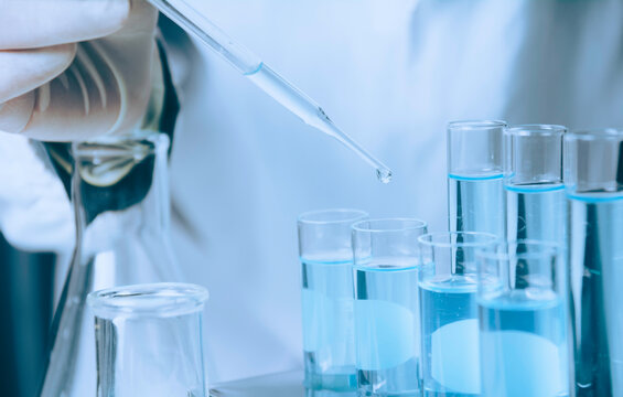 Researcher with glass laboratory chemical test tubes with liquid for analytical , medical, pharmaceutical and scientific research concept.