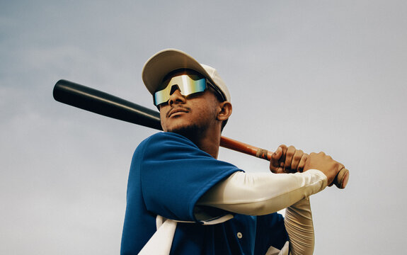Professional baseball player in action wearing polarized sunglasses during game day holding a bat