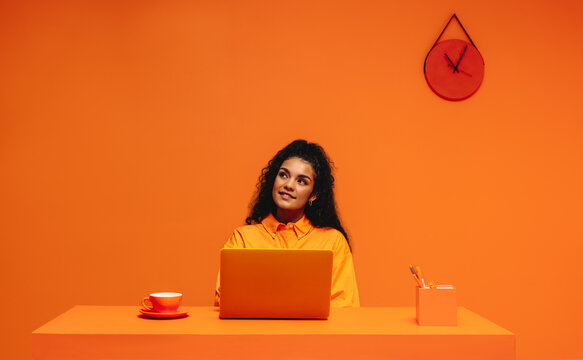 Fototapeta Pensive freelancer working in a vibrant, monochromatic office setting emphasizing creativity and focus