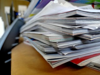 Stack of papers, files, data, books in a shelf in a office drawer.