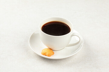 White cup of fresh brewed black coffee with cookie