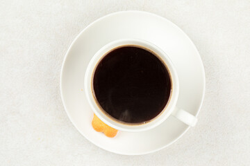 White cup of fresh brewed black coffee with cookie