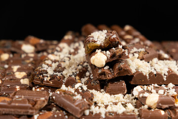 Pieces of broken organic milk chocolate with nuts and raisins. Healthy sweets