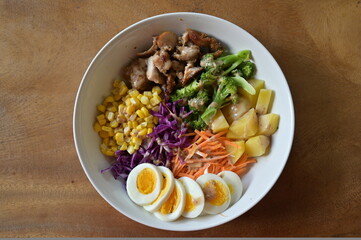 Vegetable salad top down view with various of vegetables, potato, corn, and slice eggs
