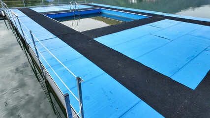 A serene outdoor swimming pool on a floating dock, ideal for summertime leisure, highlighting water safety and relaxation