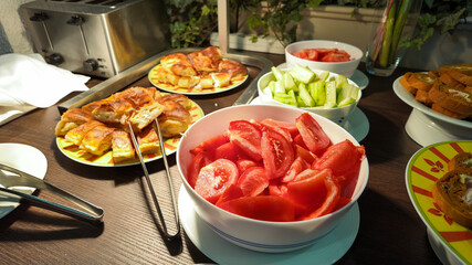 A vibrant Mediterranean breakfast buffet featuring fresh tomatoes, cucumbers, and pastries, perfect for healthy eating concepts and holiday gatherings