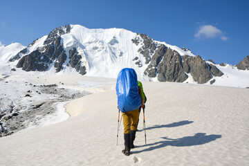 People go up to mountain on the glacier under clouds. High mountain view.