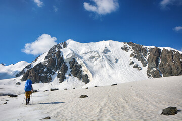 People go up to mountain on the glacier under clouds. High mountain view.