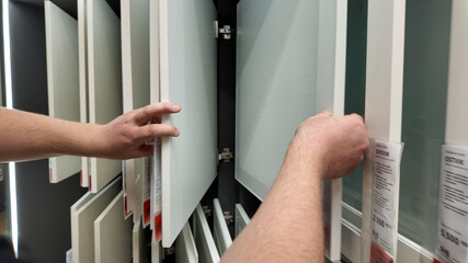 A person inspecting kitchen cabinet samples for home renovation, highlighting interior design...