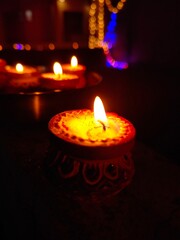 burning candles on the wall with some blur Diya's 