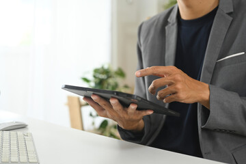 Fototapeta premium Professional businessman reviewing financial data on digital tablet at desk