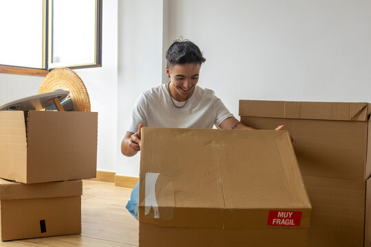 Trans man unpacking boxes in new home