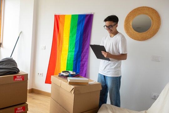 Trans man with pride flag settling into new home