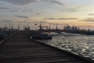 Landscape with fishing boats. dock at low tide in the morning with boats and wooden bridge. Fishing boats at the pier in the harbor at low tide. Dock scene at sunrise