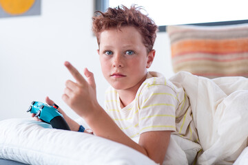 Young male gamer holding a game controller indoors