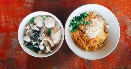 Indonesian most famous street food, a bowl of Mie Bakso (meatballs) served with rice noodles, dumplings, green vegetables, tripe, and chicken feet 