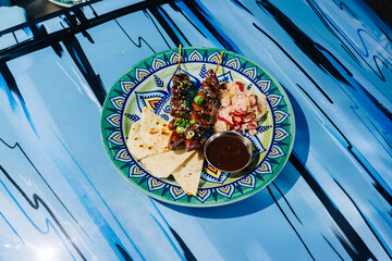 Outdoor dining with skewered chicken hearts yakitori and salads