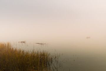 Quiet Morning at the Lake with Wooden Boat in Thick Fog