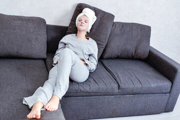 A young woman applies a facial mask at home. A cozy moment of self-care that emphasizes the importance of relaxation and skincare in a comfortable setting.