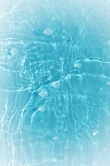 Blue water with ripples on the surface. Defocus blurred transparent blue colored clear calm water surface texture with splashes and bubbles. Water waves with shining pattern texture background.	