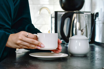 A young woman enjoys brewing coffee in her cozy kitchen early in the morning. The perfect moment to kickstart the day with a fragrant cup that energizes.