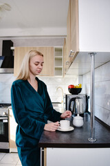 A young woman enjoys brewing coffee in her cozy kitchen early in the morning. The perfect moment to kickstart the day with a fragrant cup that energizes.