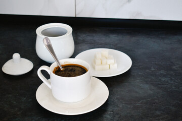 A close-up of a cup of coffee on the kitchen counter. A cozy detail that highlights the atmosphere of home comfort and the joy of simple pleasures.