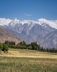 Rural vertical landscape view of snow-capped Hindu Kush mountain range near Ishkashim, Wakhan...