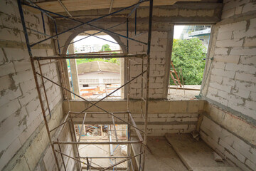 Under construction home or house with scaffolding on site in village. Old unfurnished rental property, living space units. lifestyle. Renovation.